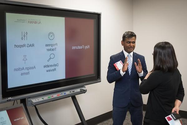 Faculty members discuss a presentation at the Faculty Tech Showcase.